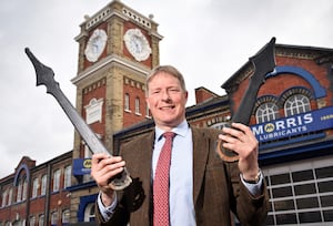 Morris Lubricants executive chairman Andrew Goddard holding the new clock hands with the famous Clock Tower in the background.