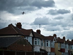 An aircraft takes off from London's Heathrow Airport over residential homes in west London