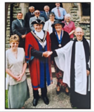 Derek at his civic service with his wife Pam and surrounded by other council members