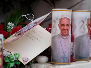 Candles with the pope's image next to a card