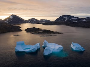 Large Icebergs float away as the sun rises near Greenland