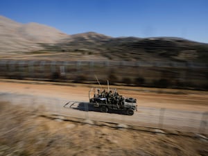 An Israeli army vehicle speeding along a road in Syria