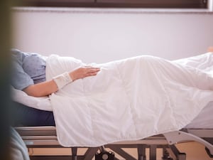 Patient lies in bed at a hospice