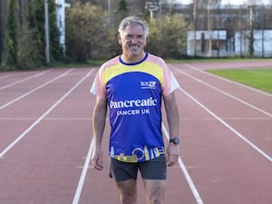 Tony Audenshaw smiling while wearing a Pancreatic Cancer UK running top at London Marathon Community Track in Stratford, east London