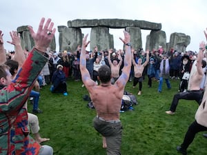 People take part in the winter solstice celebrations during sunrise at Stonehenge in Wiltshire.