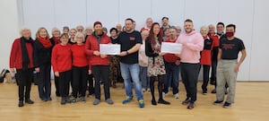 The Morris dancers handing the cheques to the charities 