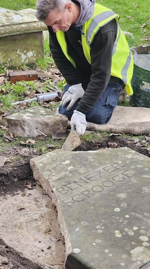 Experts work on the gravestone.