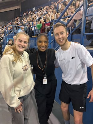 Declan Johnson and girlfriend Megan Potts flank British sporting legend Denise Lewis by the side of the track at the Utilita Arena in Birmingham