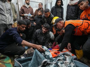 Palestinians mourn over the bodies of civil defence workers