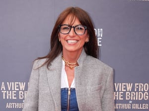 A close-up of Davina McCall, who is smiling and wearing glasses