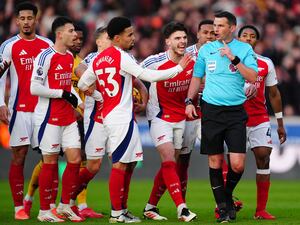 Declan Rice, centre right, shouts at referee Michael Oliver, second right, as Arsenal players protest against Myles Lewis-Skelly's red card at Wolves