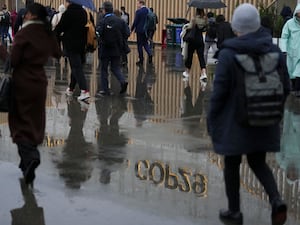 Attendees arrive at the venue in the rain