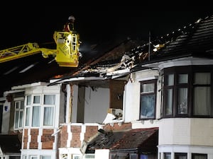 Fire crew on a cherrypicker at the scene of a house blaze in Ilford