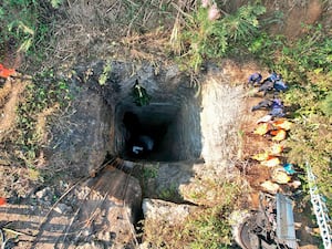 An image provided by Indian Army shows rescue workers standing around a coal mine where at least nine workers are trapped