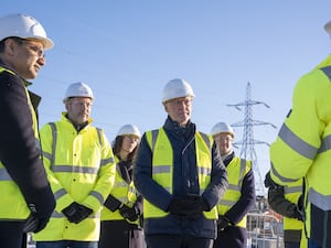 John Swinney and other dignitaries in hi-viz vests under blue skies