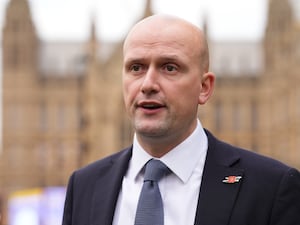 A close-up of Stephen Flynn in a suit and tie