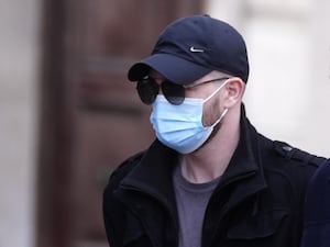 Kyle Shaw, wearing a face mask, baseball cap and sunglasses, arrives at Liverpool Crown Court