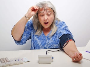 White-haired woman with surprised expression when taking her blood pressure measurements