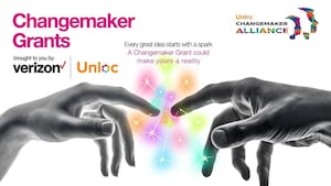 Two hands touching to create a colourful spark. Unloc Changemaker Grants, powered by The Changemaker Alliance and Verizon Business