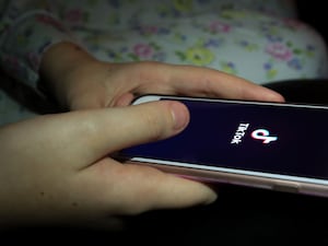 A young girl uses the TikTok app on a smartphone