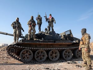 Syrian opposition fighters on a seized military armoured vehicle