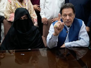 Pakistan’s former Prime Minister Imran Khan and his wife Bushra Bibi speak to the media