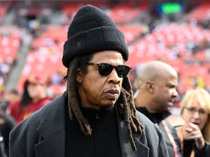 Jay-Z standing on the field before an NFL football game