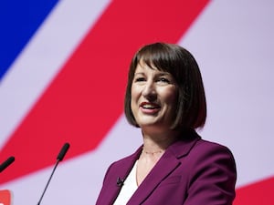 Chancellor Rachel Reeves smiling while speaking from a lectern