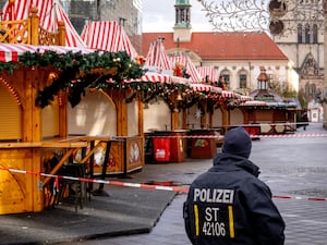 Police officer at cordon beside Christmas market stalls