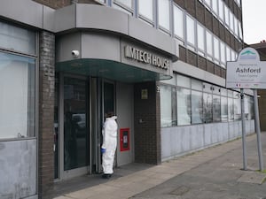 A forensics officer entering Imtech House on Woodthorpe Road in Ashford, Surrey, where a woman in her 20s died and a two-year-old girl was found with serious injuries