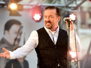 Ricky Gervais standing with a microphone