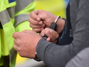 A man's hands being put in cuffs by a police officer