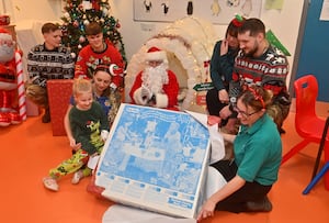 Esme Ridge, 6 and play specialists Georgia Newsome and Dawn White, with staff from RAF Shawbury opening presents for the ward