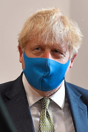 Prime Minister Boris Johnson follows his own advice and wears a mask