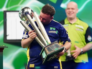 Luke Littler kisses the trophy