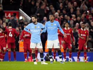 Manchester City’s Bernardo Silva and Manuel Akanji (right) react as Liverpool players celebrate in the background