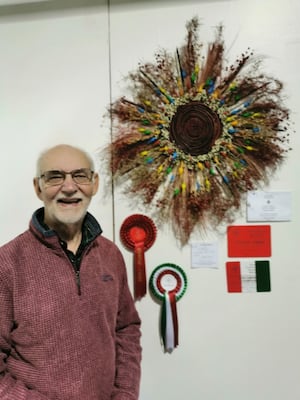 Robert Loveridge with his catherine wheel floral exhibit and winning rosettes