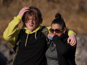 A student and a family member walk from the Antioch High School after a shooting in Nashville