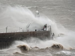 Waves crash against Folkestone harbour wall in Kent