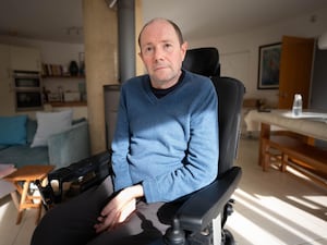 Phil Newby sitting in his wheelchair in a patch of sunlight