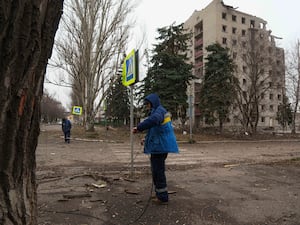 Man checking wiring outside damaged high-rise building