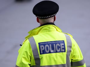 An image of a police officer in uniform from behind