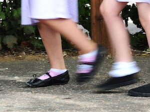 Blurred photo of school children's feet running past