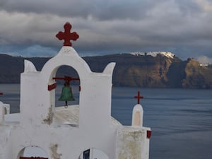 An island visible in the distance through a white bell tower with a cross on top