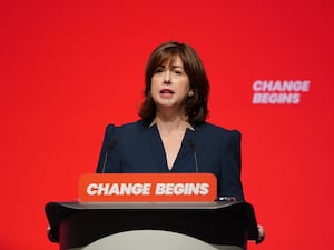 Lucy Powell on stage with 'Change Begins' on lectern