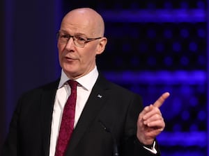 John Swinney pointing with one hand while speaking