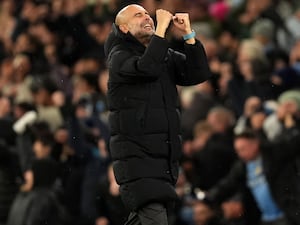 Pep Guardiola clenches both fists and looks to the skies as he celebrates a goal