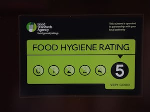 A Food Standards Agency rating sticker on a window of a restaurant