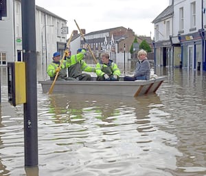 Floods in Shrewsbury. Hairdresser Karen Bradbury uses the council's emergency boat to check on her hair salon in Longden Coleham.