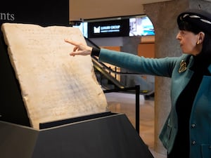 A Sotheby's expert points at the ancient tablet